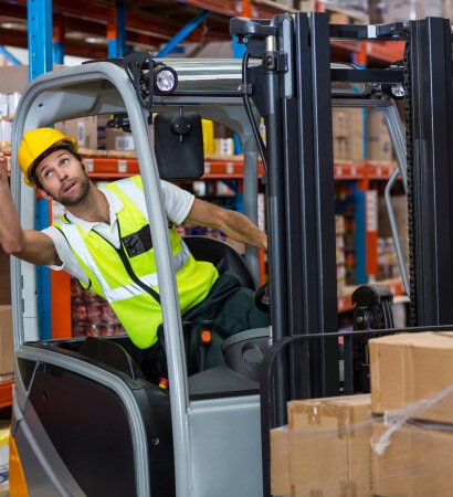 Warehouse forklift operator selecting and retrieving specific cargo packages during the product picking stage at NSAG Industries.